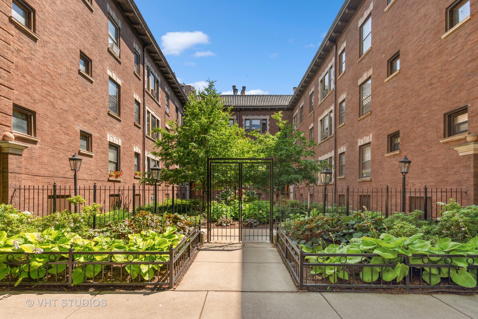 3755 North Pine Grove Avenue, Unit 2 Chicago, IL 60613 - Photo 2 of 17 a front view of a multi story residential apartment building with a yard
