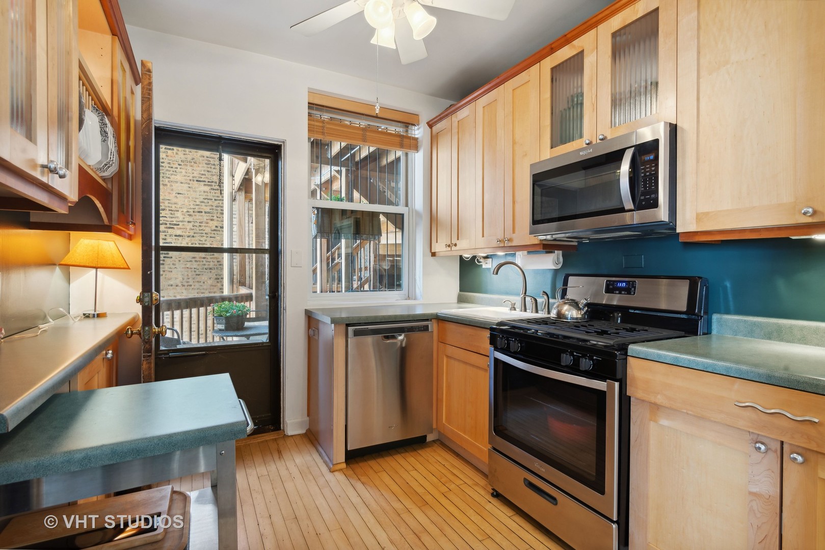 3755 North Pine Grove Avenue, Unit 2 Chicago, IL 60613 - Photo 7 of 17 a kitchen with stainless steel appliances a stove a sink and a microwave