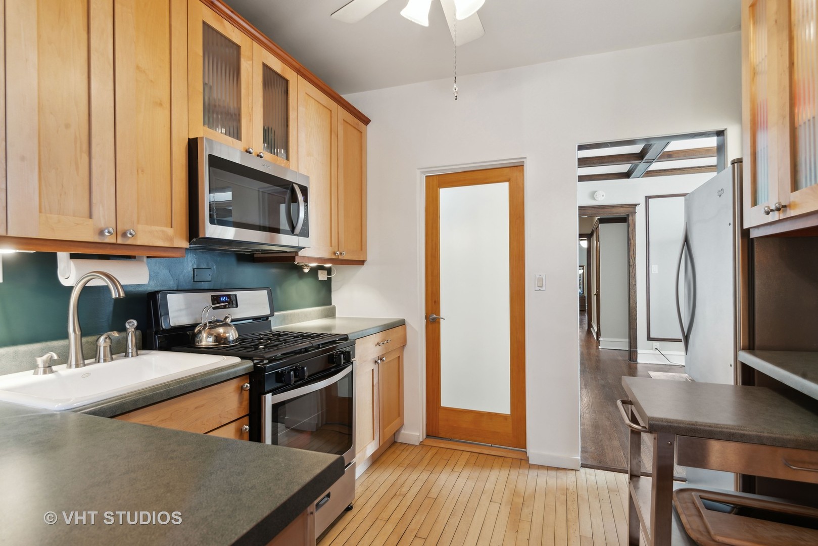3755 North Pine Grove Avenue, Unit 2 Chicago, IL 60613 - Photo 8 of 17 a kitchen with stainless steel appliances granite countertop a stove refrigerator and a microwave
