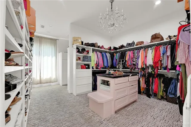 a view of walk in closet with clothes and shoes
