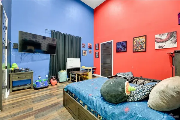 a bedroom with a bed a flat screen tv and dresser