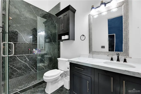 a bathroom with a sink toilet vanity and shower