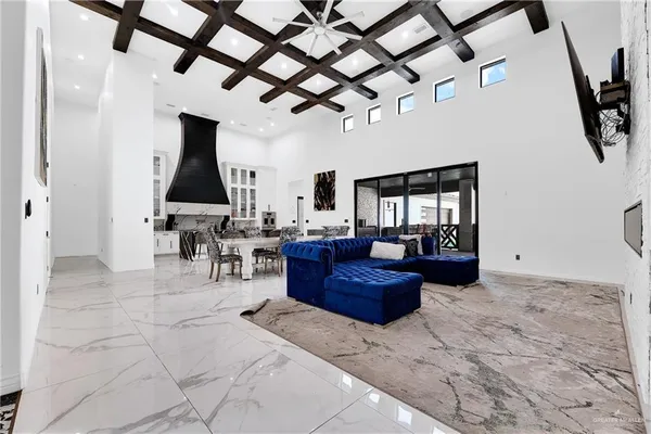 a living room with furniture a chandelier and a rug
