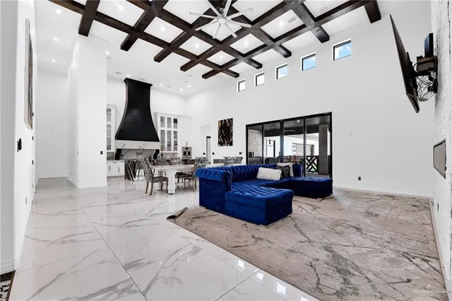 a living room with furniture a chandelier and a rug
