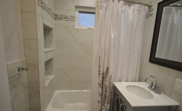 a bathroom with a sink a shower and a mirror