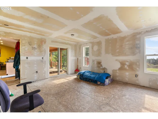 a spacious bedroom with a bed and large windows