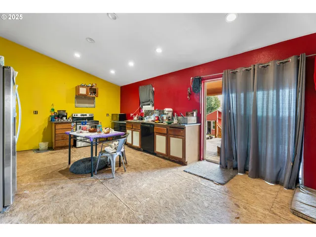a living room with furniture a flat screen tv and a kitchen counter