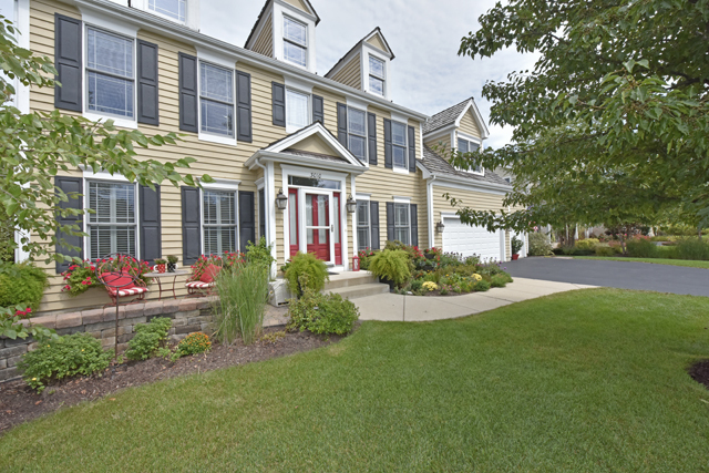 a front view of a house with garden and porch