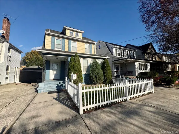 a view of a house with a small yard and wooden fence