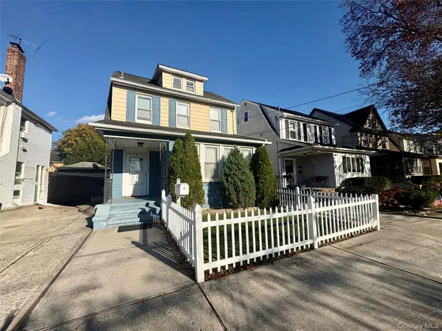 a view of a house with a small yard and wooden fence
