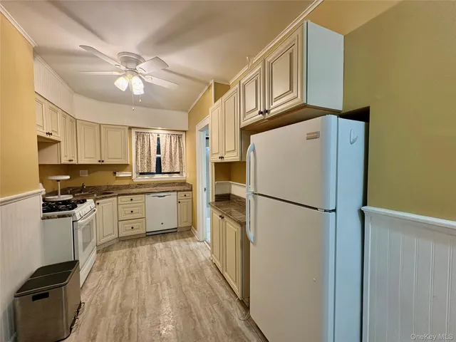 a kitchen with a refrigerator a stove cabinets and wooden floor