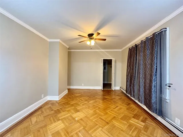 a view of an empty room with closet and a window