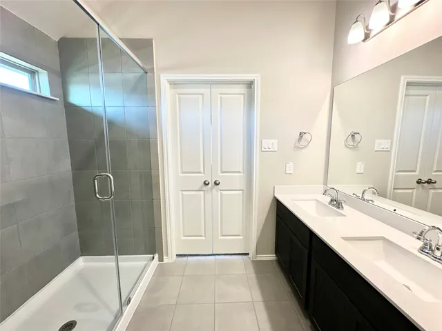 a bathroom with a double vanity sink a mirror and a