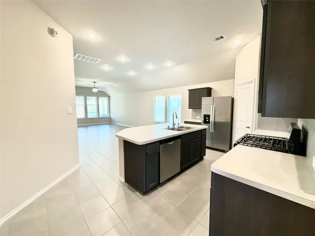 a kitchen with a sink a counter top space appliances and cabinets