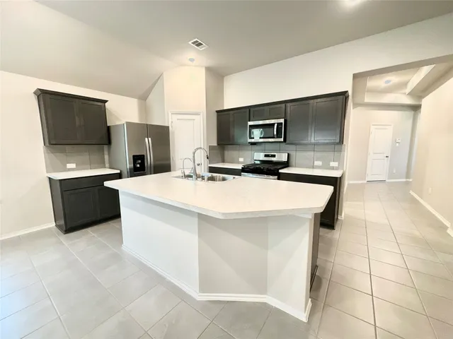 a kitchen with stainless steel appliances a sink and a refrigerator