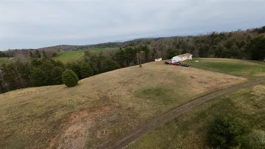 a view of a field with trees in the background