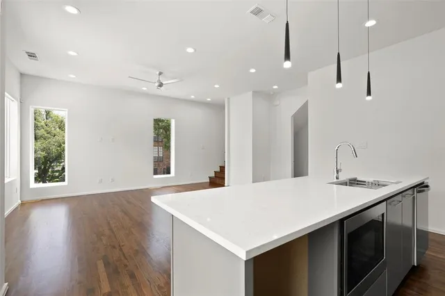 a kitchen with kitchen island a sink appliances and a large window