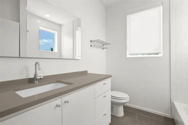 a bathroom with a toilet a sink and mirror