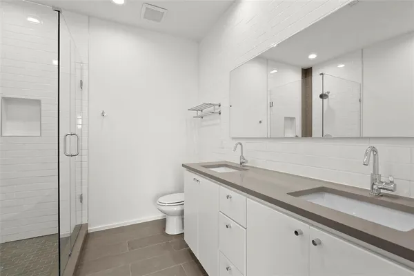 a bathroom with a granite countertop sink a toilet and a mirror