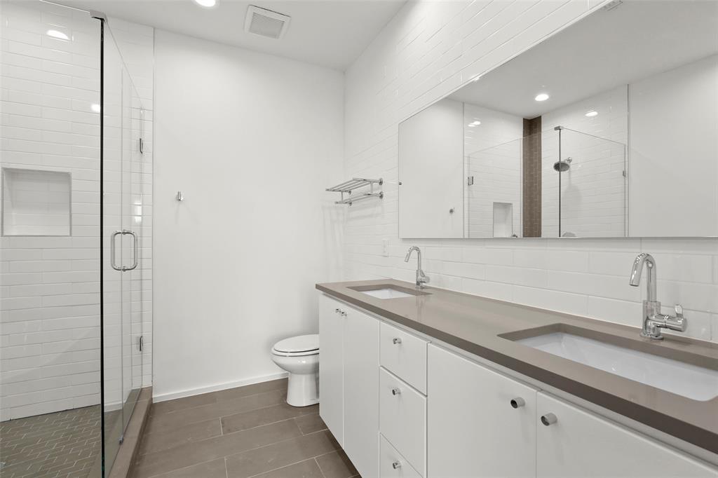6250 Oram Street, Unit 102 Dallas, TX 75214 - Photo 15 of 21 a bathroom with a granite countertop sink a toilet and a mirror
