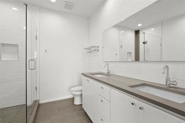 a bathroom with a granite countertop sink a toilet and a mirror