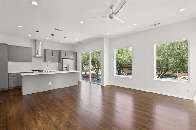 a large kitchen with stainless steel appliances granite countertop a large window