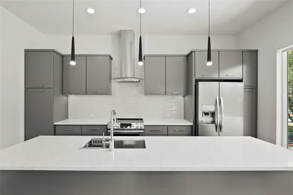 a kitchen with kitchen island white cabinets and refrigerator