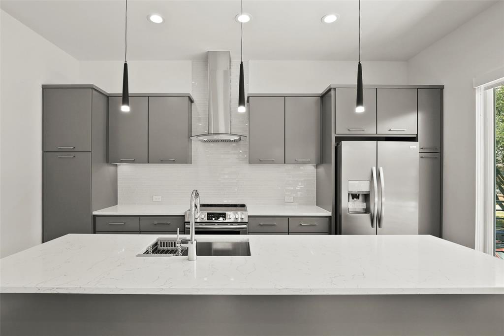6250 Oram Street, Unit 102 Dallas, TX 75214 - Photo 7 of 21 a kitchen with kitchen island white cabinets and refrigerator