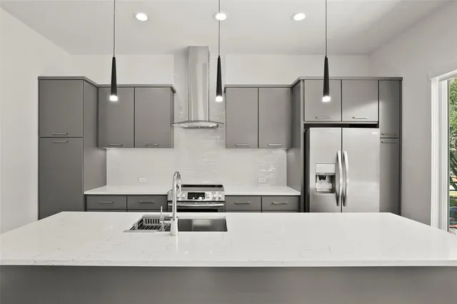 a kitchen with kitchen island white cabinets and refrigerator