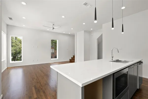 a kitchen with kitchen island a sink appliances and a large window