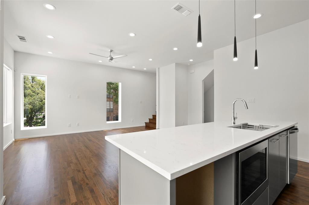 6250 Oram Street, Unit 102 Dallas, TX 75214 - Photo 10 of 21 a kitchen with kitchen island a sink appliances and a large window