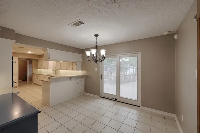 a large white kitchen with a sink and dishwasher a refrigerator with white cabinets