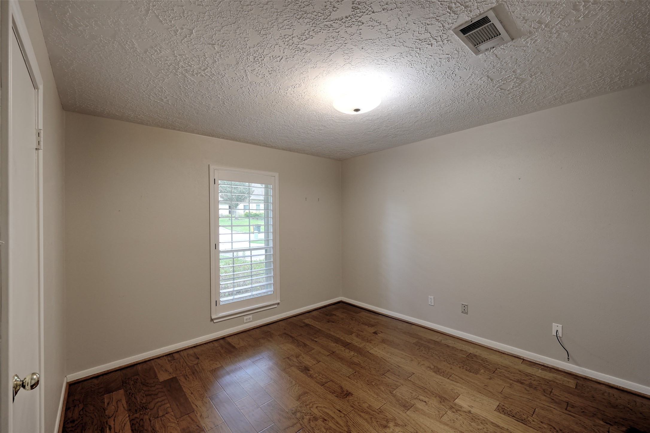 206 Virginia Lane Conroe, TX 77304 - Photo 17 of 36 an empty room with wooden floor and windows