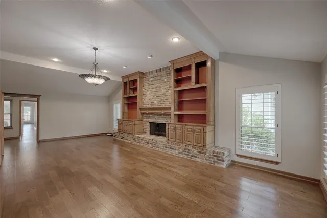 an empty room with a fireplace and window