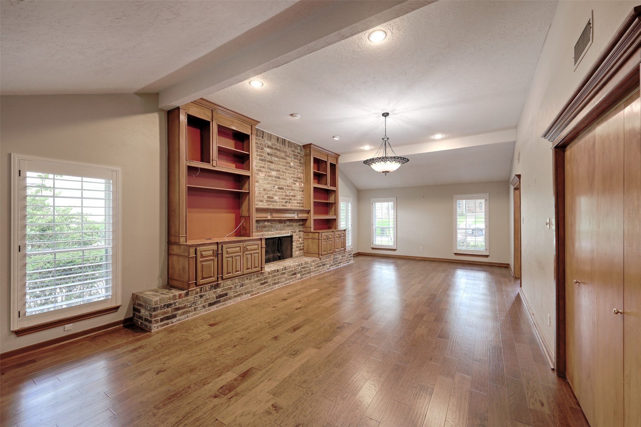 206 Virginia Lane Conroe, TX 77304 - Photo 9 of 36 an empty room with wooden floor fireplace and windows