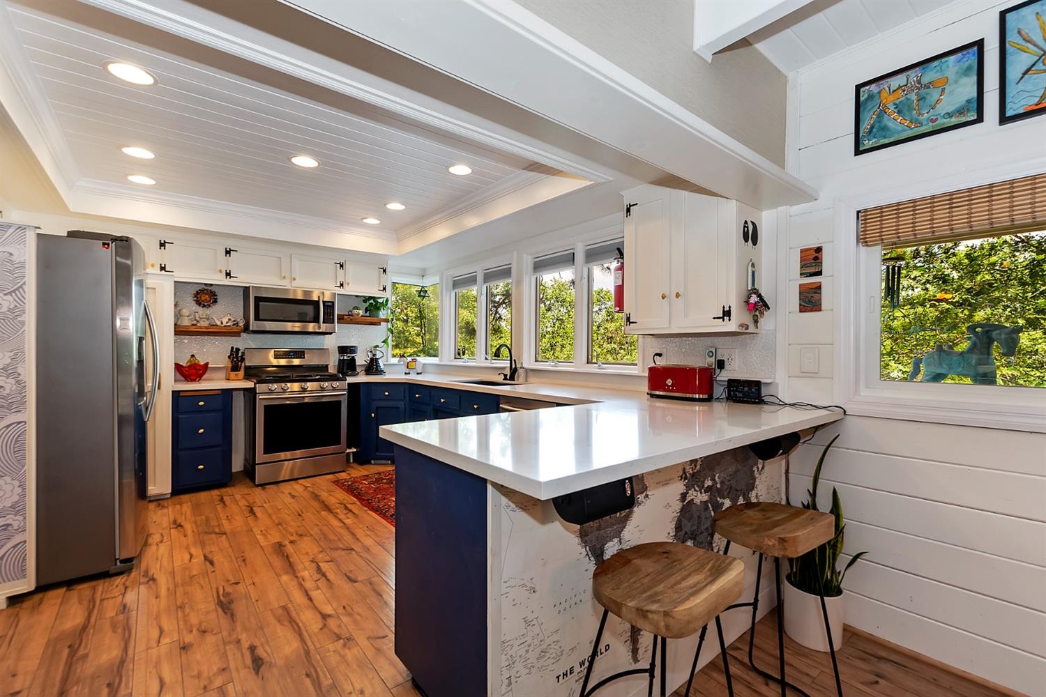 28277 Arbon Lane Lake Arrowhead, CA 92352 - Photo 12 of 50 a kitchen with stainless steel appliances kitchen island a table chairs in it and wooden floors