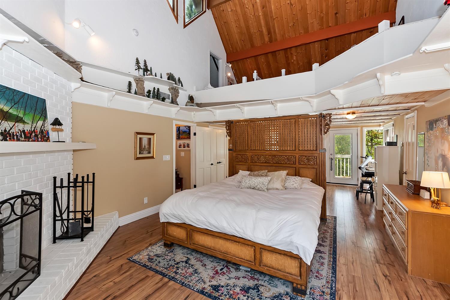 28277 Arbon Lane Lake Arrowhead, CA 92352 - Photo 22 of 50 a bedroom with a bed a table and wooden floor