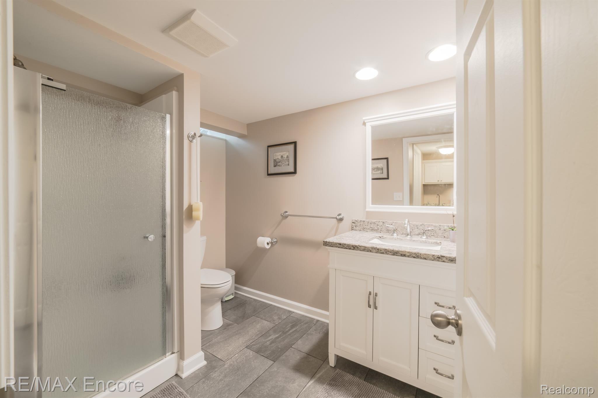 2555 New England Drive Rochester, MI 48309 - Photo 45 of 61 Fantastic lower level bath with ceramic tile, spacious shower, gorgeous vanity with granite counter top