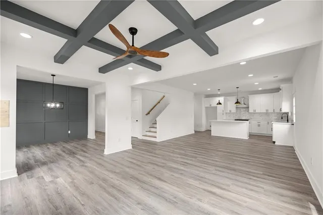 a view of empty room with wooden floor and ceiling fan