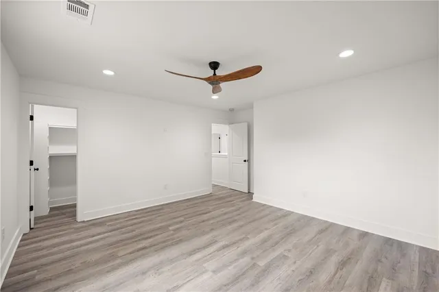 an empty room with a window and a ceiling fan