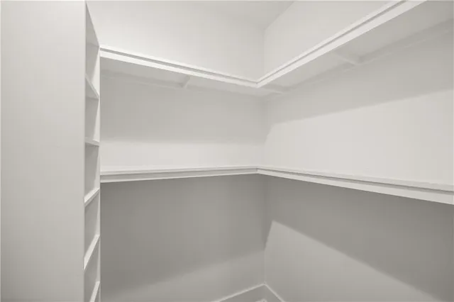 an empty room with wooden floor and ceiling fan