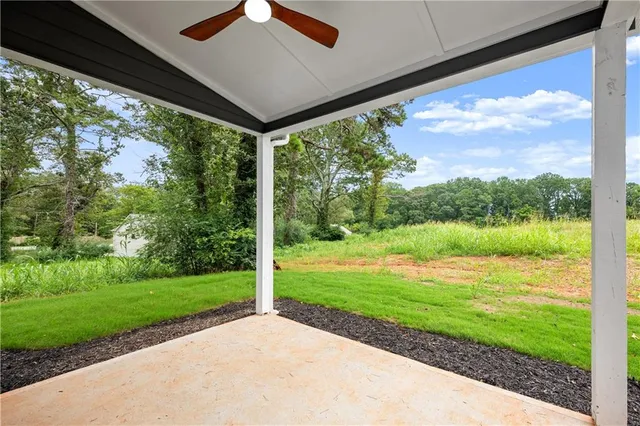 a view of a lush green forest with a house