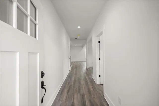a view of a hallway with wooden floor and staircase