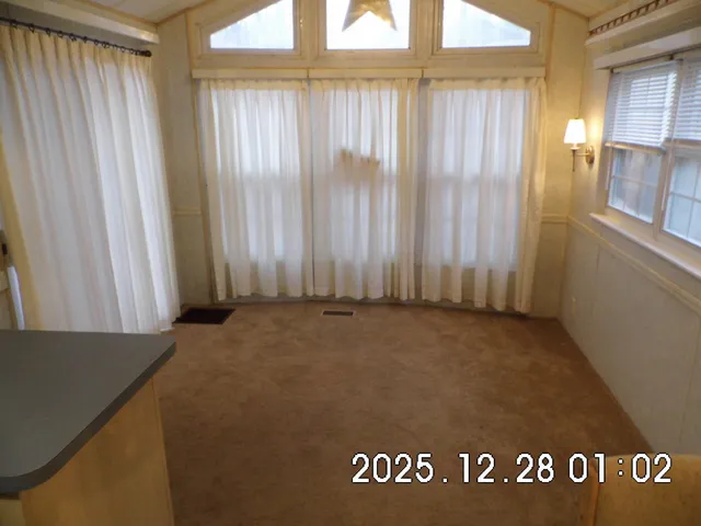 a kitchen view with stainless steel appliances kitchen island granite countertop a table chairs in it