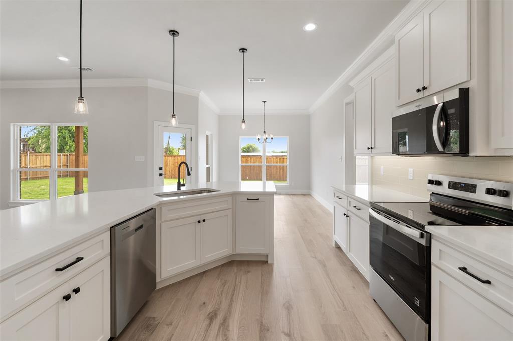 505 Limestone Circle Mabank, TX 75147 - Photo 12 of 37 a kitchen with stainless steel appliances granite countertop a sink a stove and a wooden floor