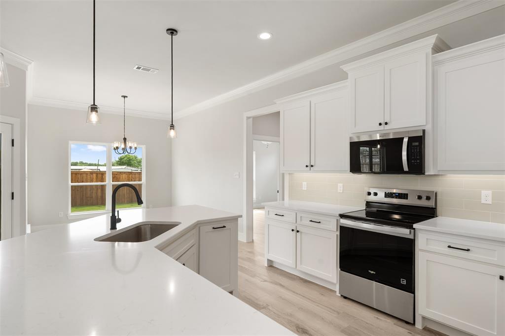 505 Limestone Circle Mabank, TX 75147 - Photo 14 of 37 a kitchen with stainless steel appliances kitchen island a sink a stove and cabinets