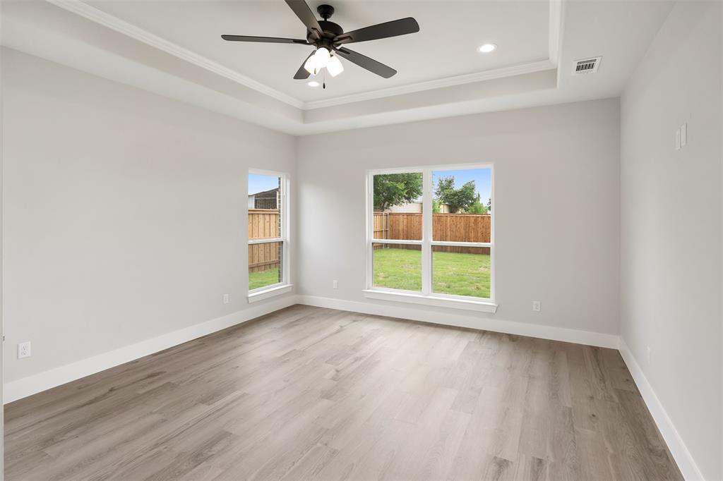 505 Limestone Circle Mabank, TX 75147 - Photo 17 of 37 an empty room with wooden floor fan and windows