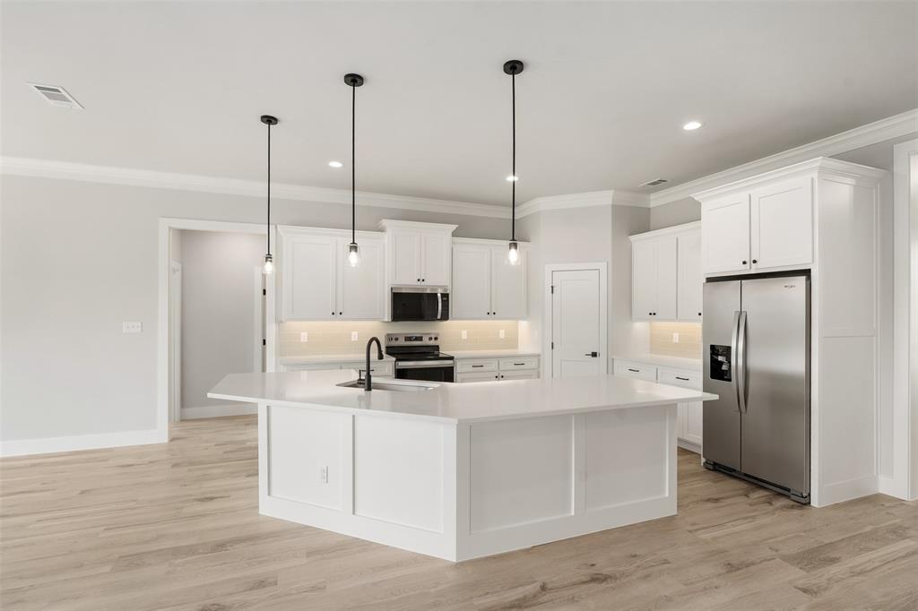 505 Limestone Circle Mabank, TX 75147 - Photo 8 of 37 a kitchen with stainless steel appliances kitchen island granite countertop a refrigerator a sink and white cabinets