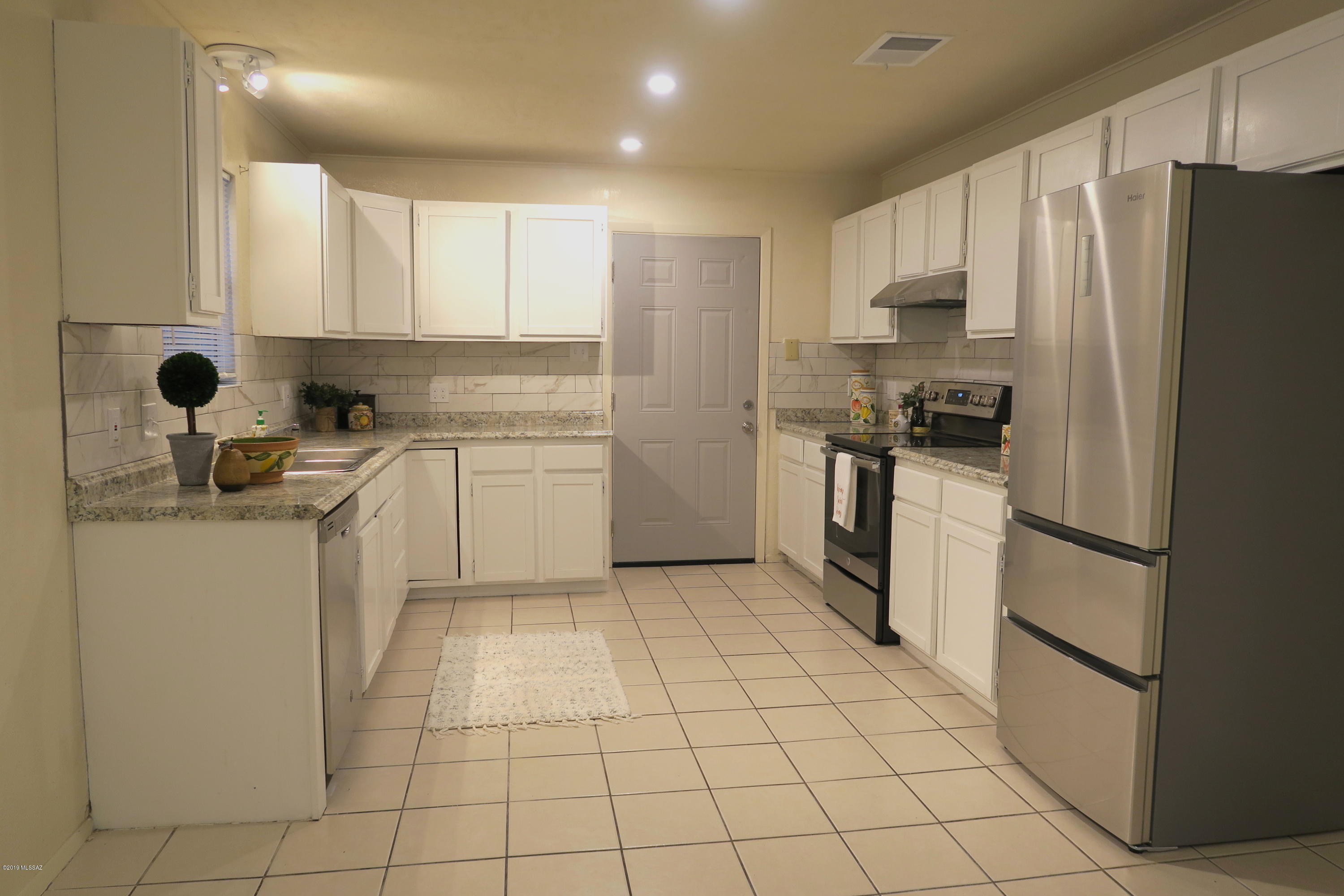 410 Sykes Circle Rio Rico, AZ 85648 - Photo 3 of 13 a kitchen with a refrigerator a stove top oven and cabinets