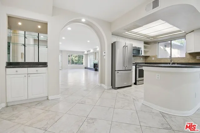a view of a hallway with wooden floor and windows